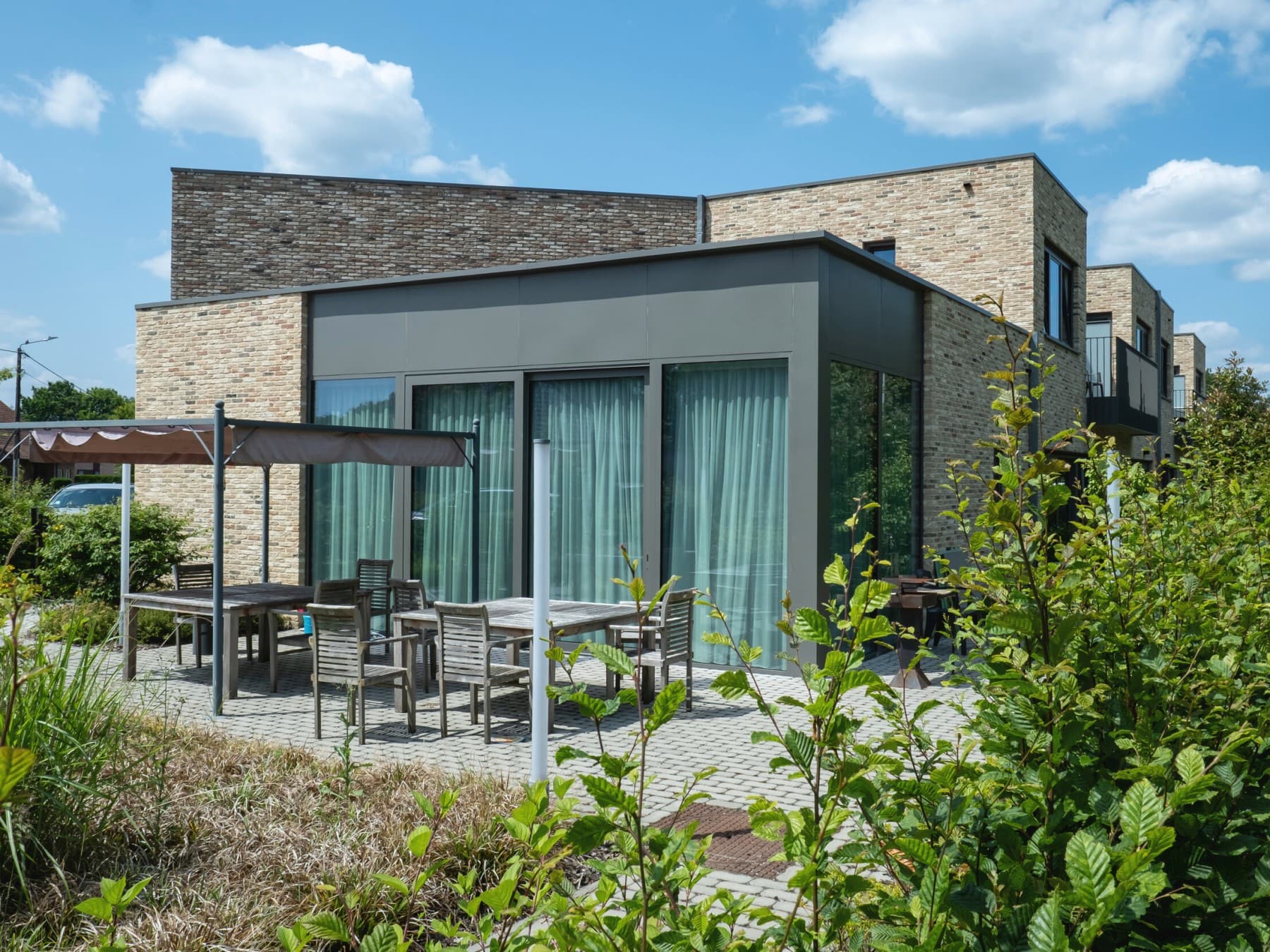 Woning van Huis50 met overdekt terras en bomen in het beeld.