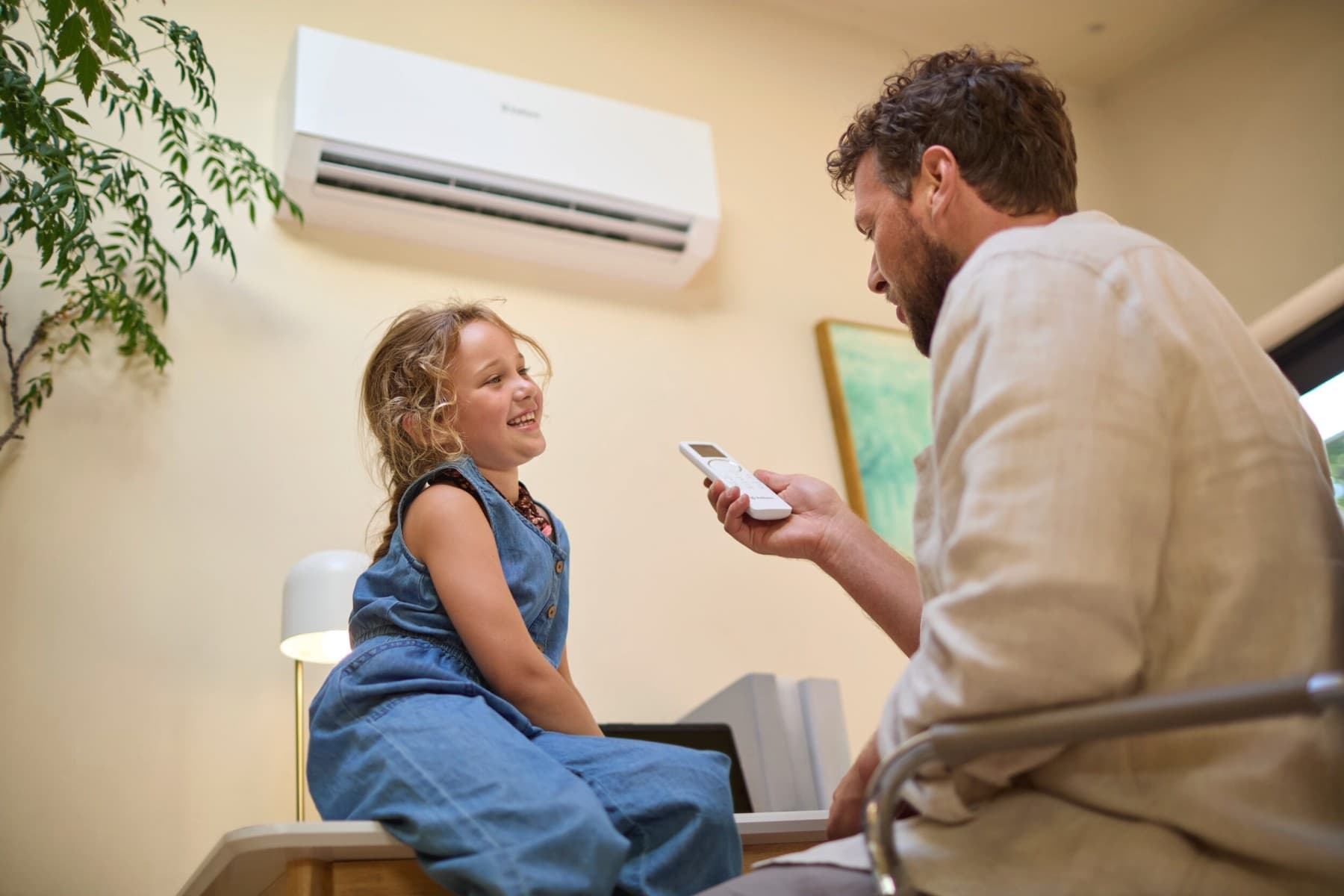 Een meisje en haar vader voor een airconditioning