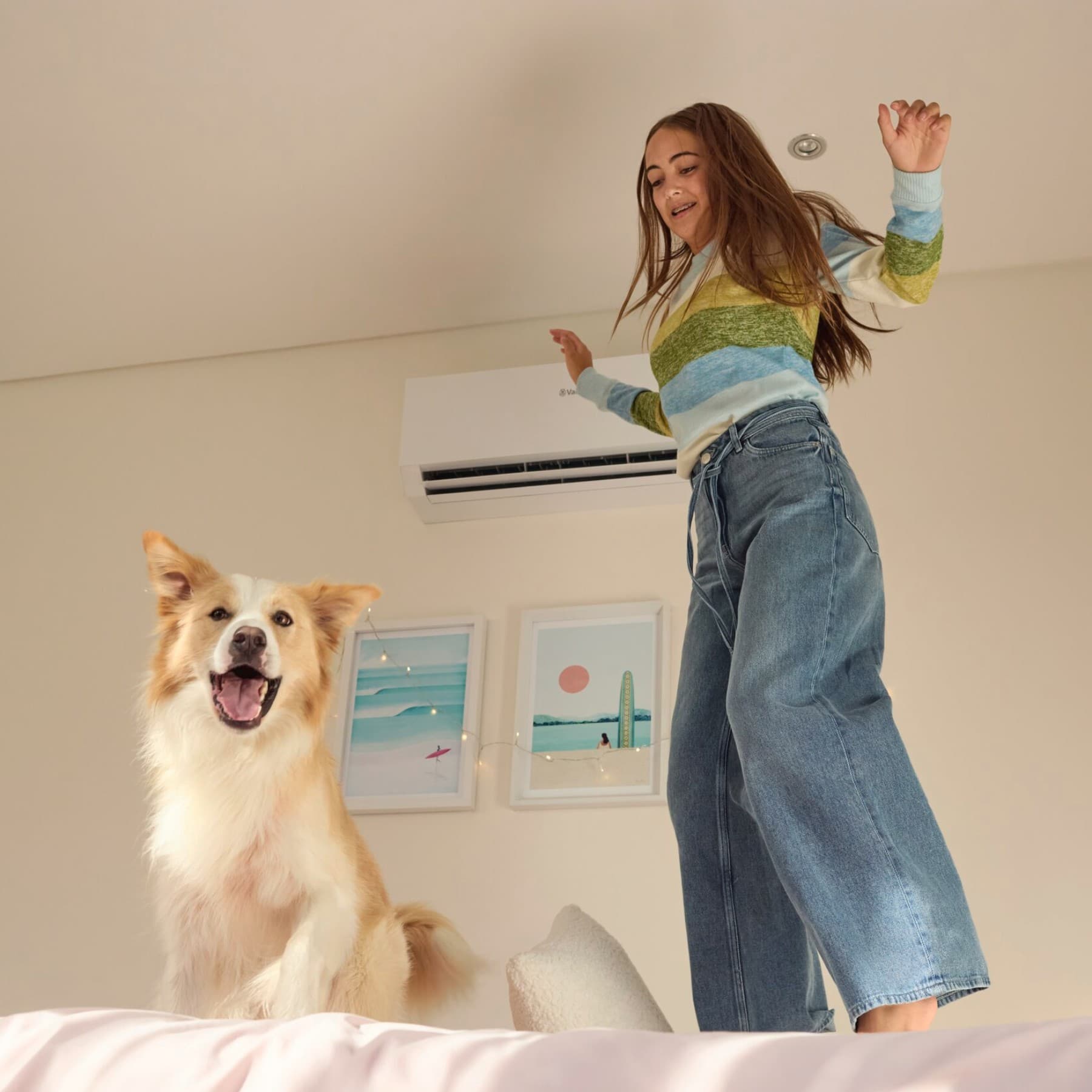 Meisje springt op bed naast een hond