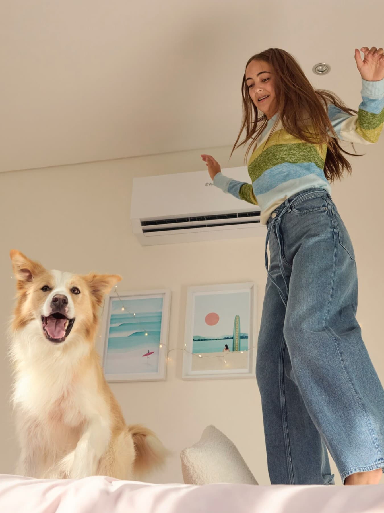 Meisje springt op bed naast een hond