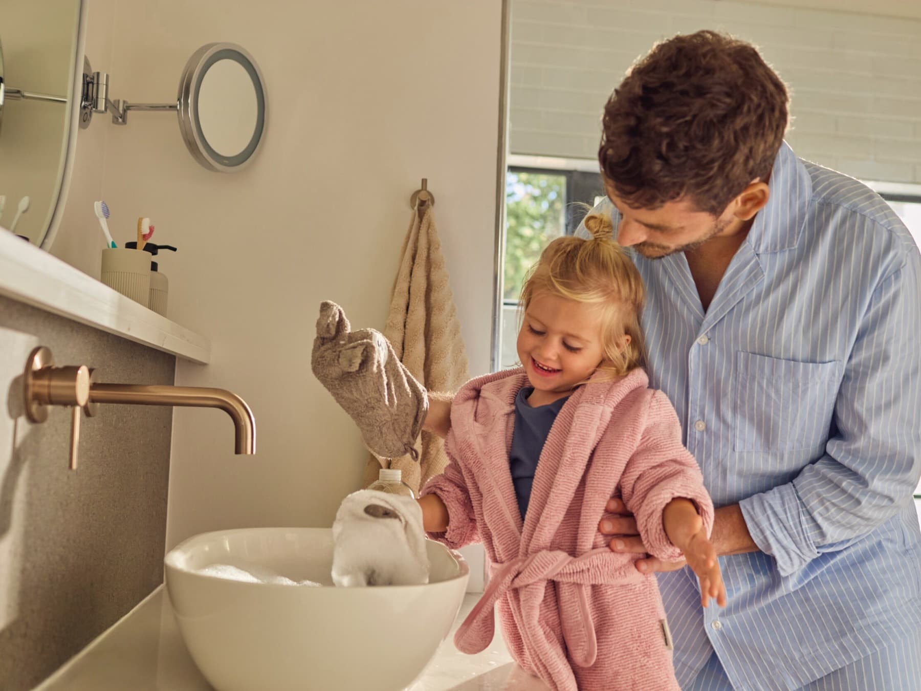 Vader die zijn dochter helpt met een washandje