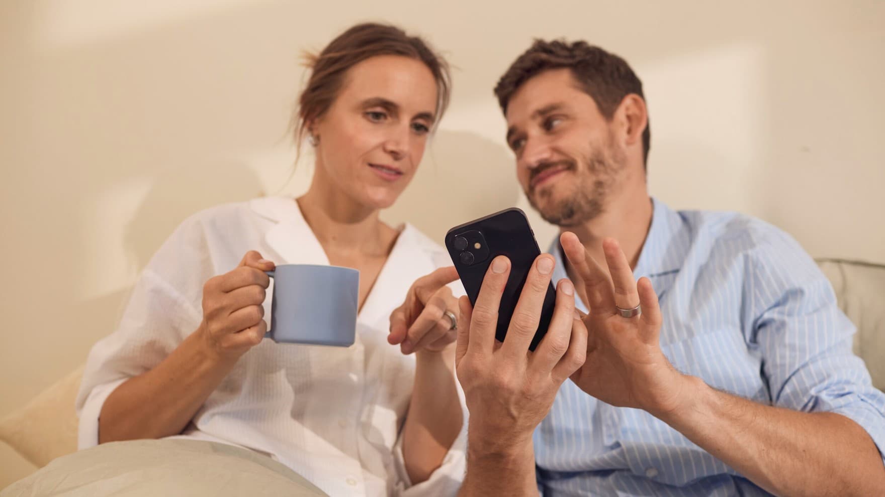 Koppel zit op een telefoon in bed