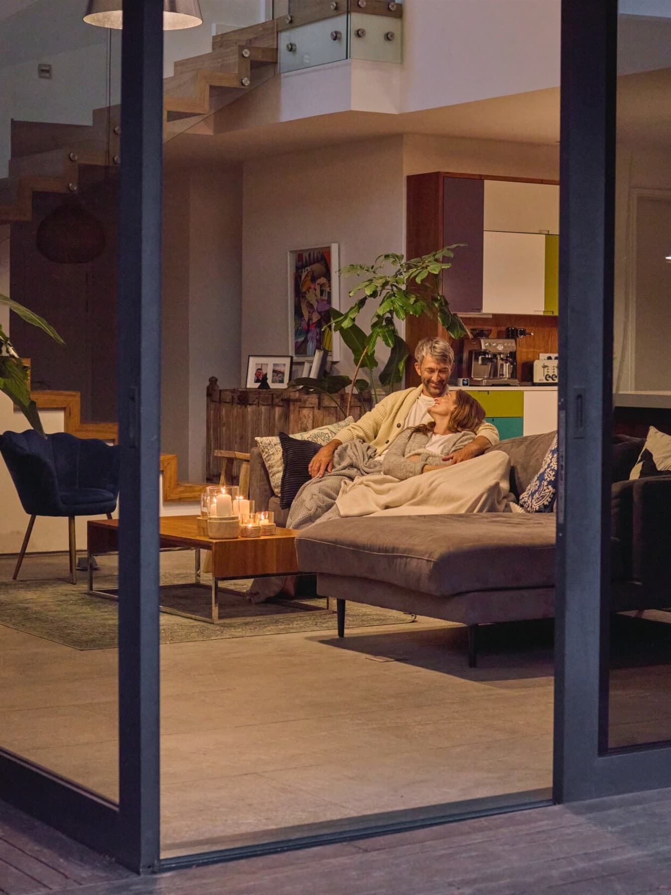 Stel zittend op de bank met de patiodeur open