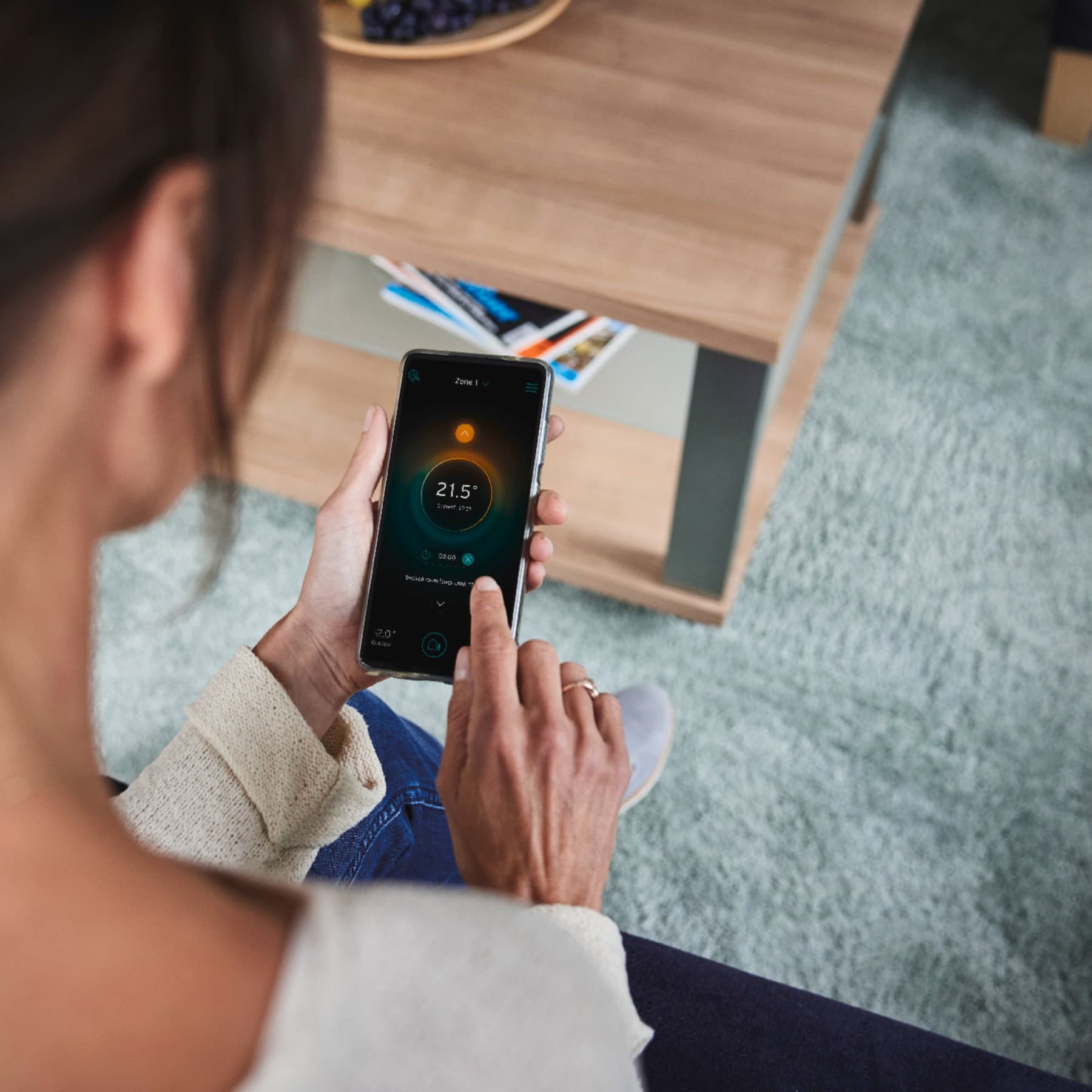 Vrouw die haar slimme systeem via haar telefoon instelt.