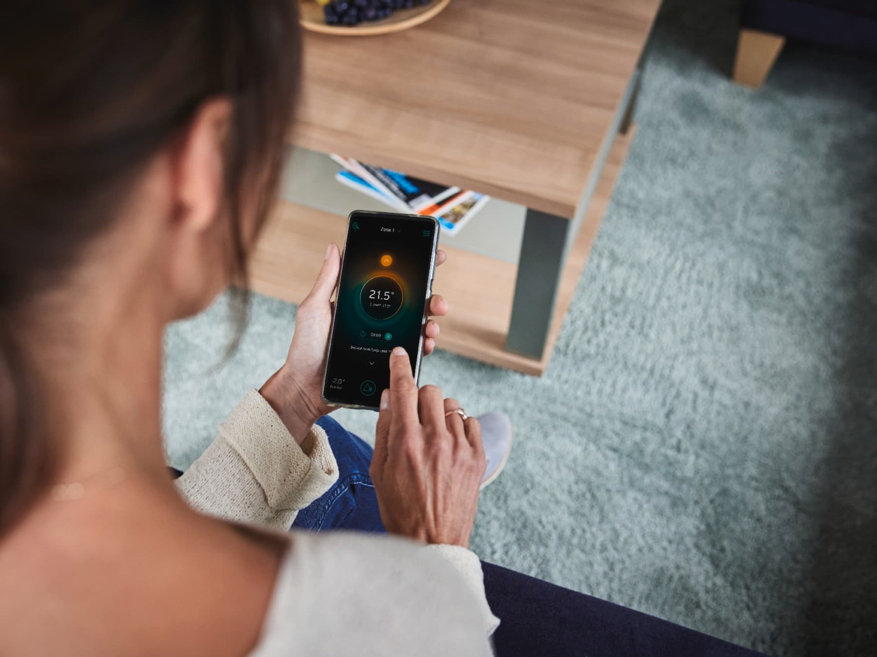 Vrouw die haar slimme systeem via haar telefoon instelt.