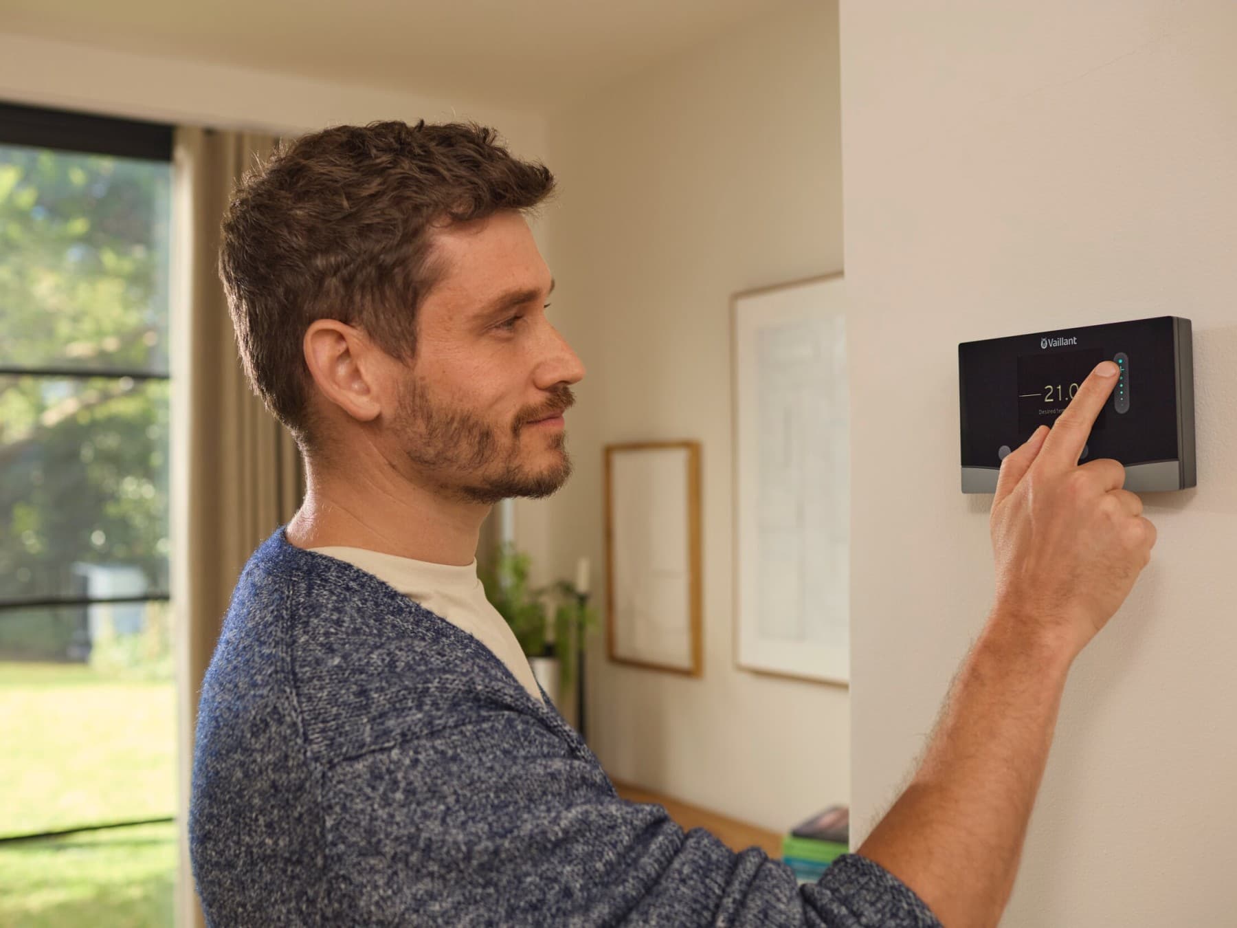 Man past temperatuur aan op de thermostaat aan de muur.