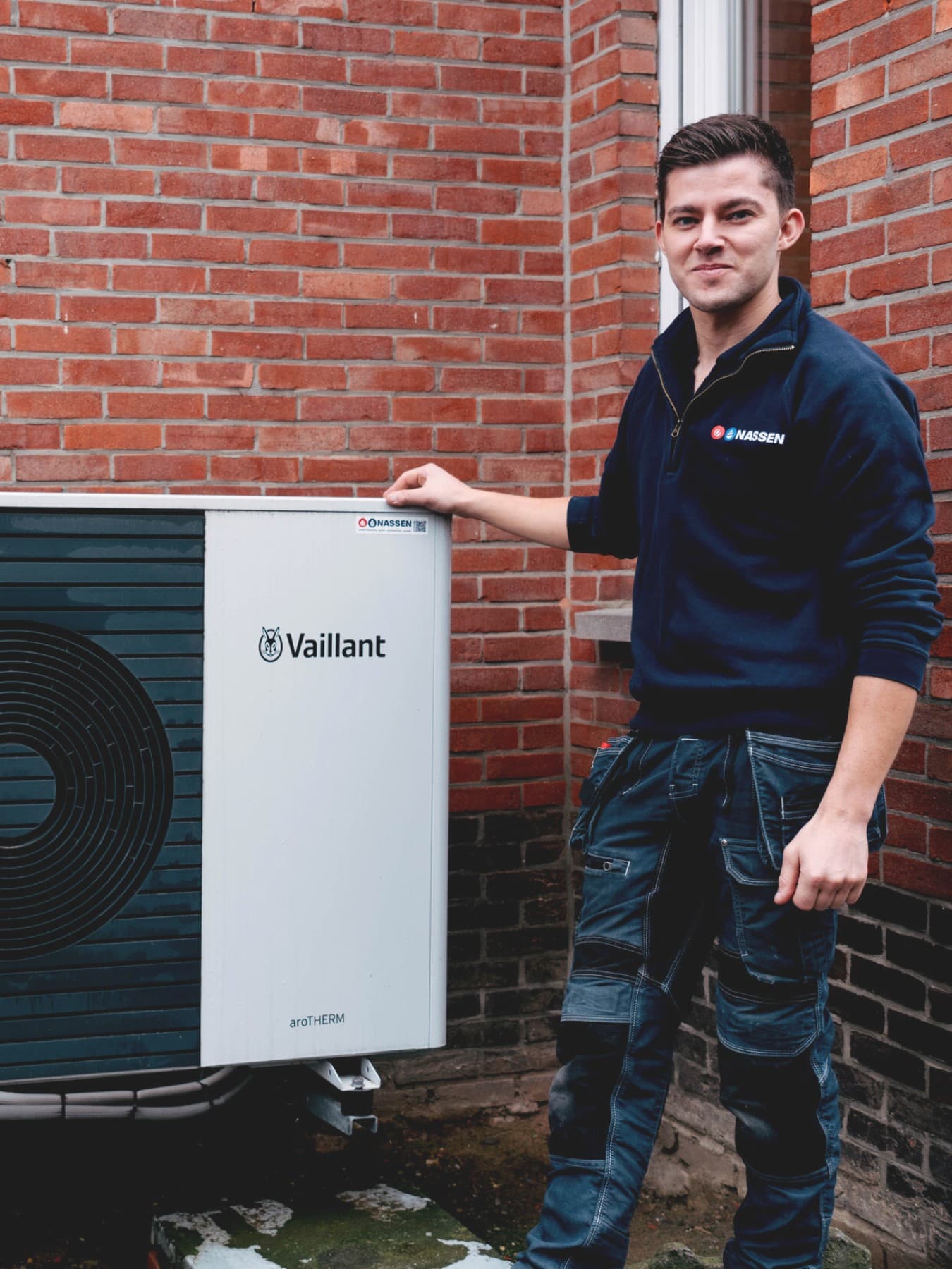 Klant en installateur staan naast buitenunit van een warmtepomp