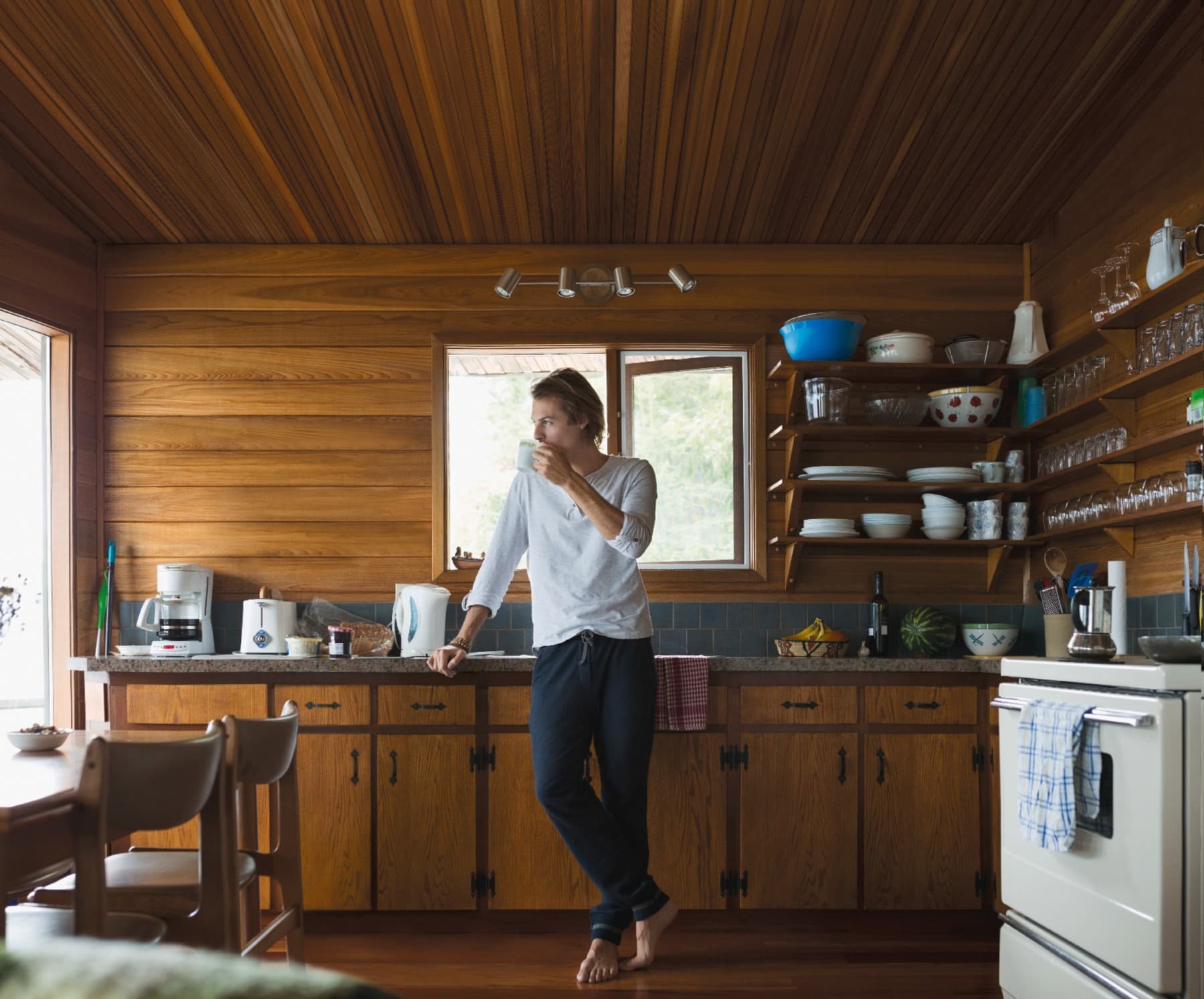 Man drinkt koffie in houten hut