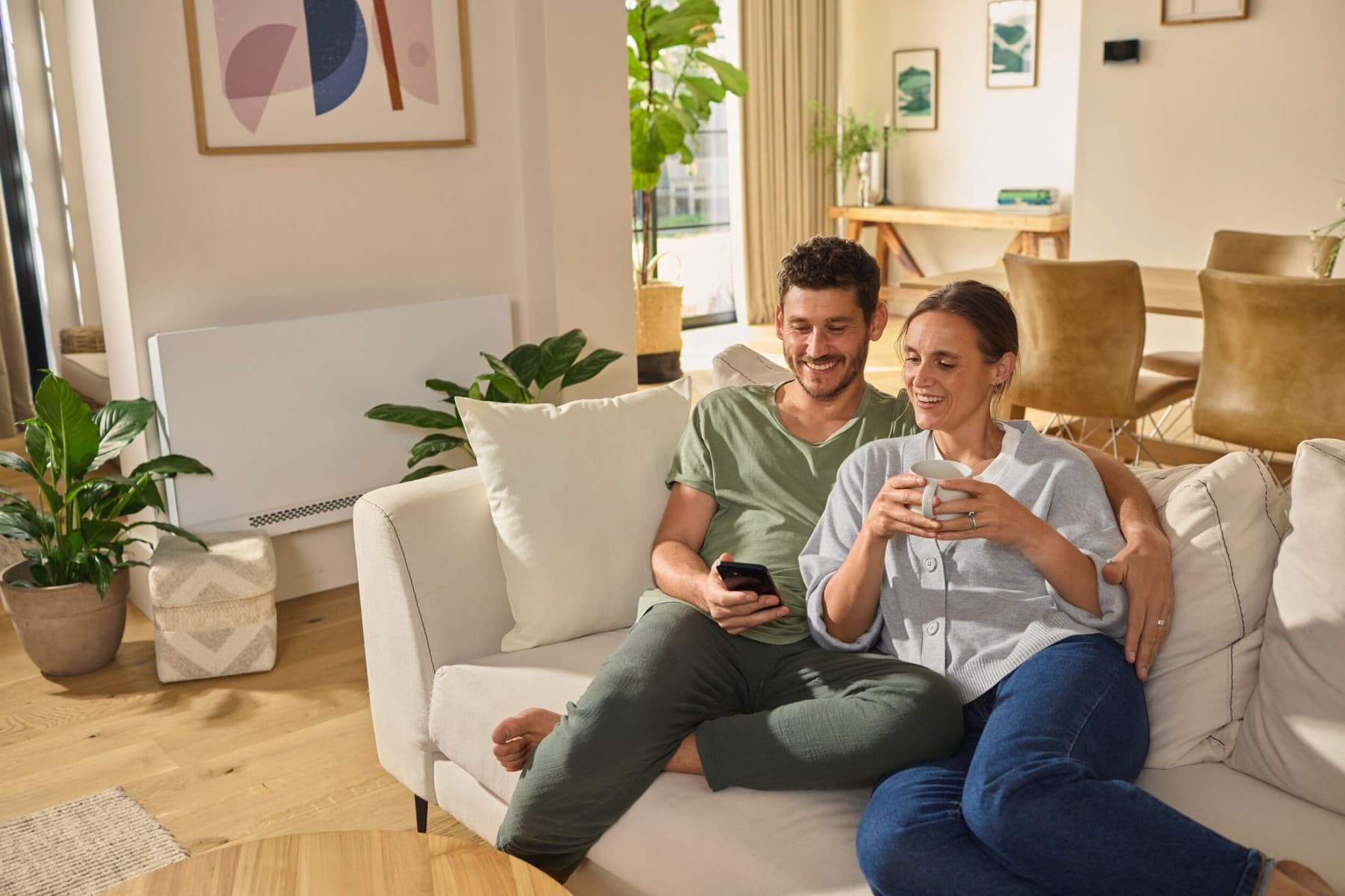 Stel zit op de bank en kijkt naar een smartphone