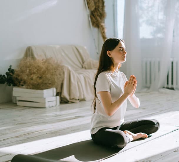 Vrouw die in de zon zit en yoga doet