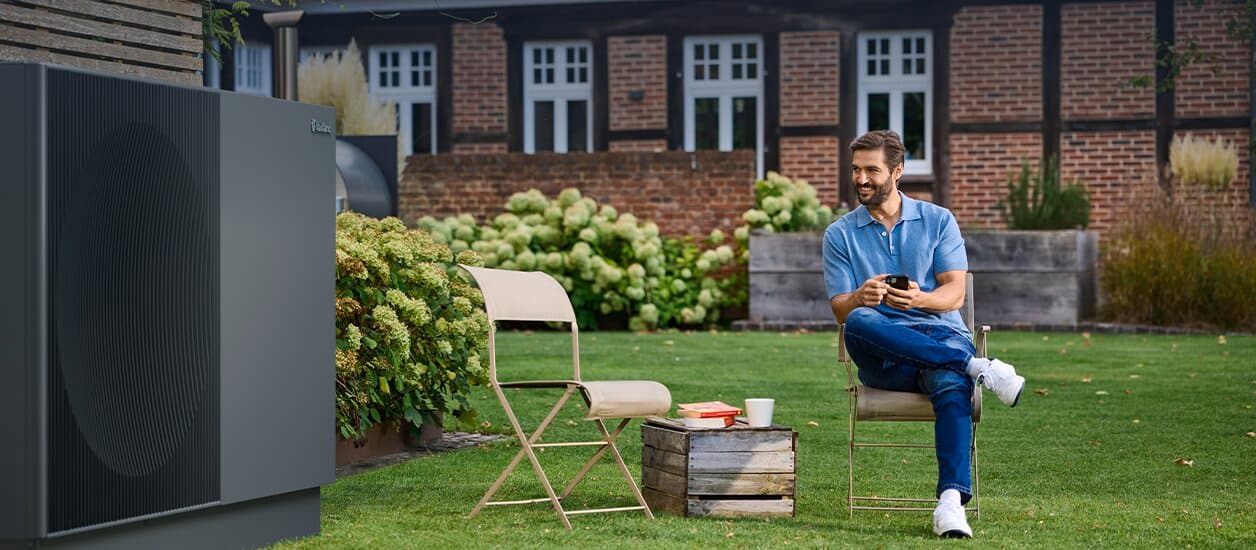 Man zit in de tuin naast een aroTHERM perform