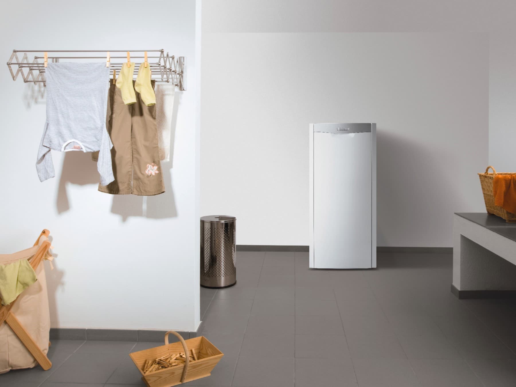 Stookolieketel in een wasruimte met kleding die aan het drogen is.