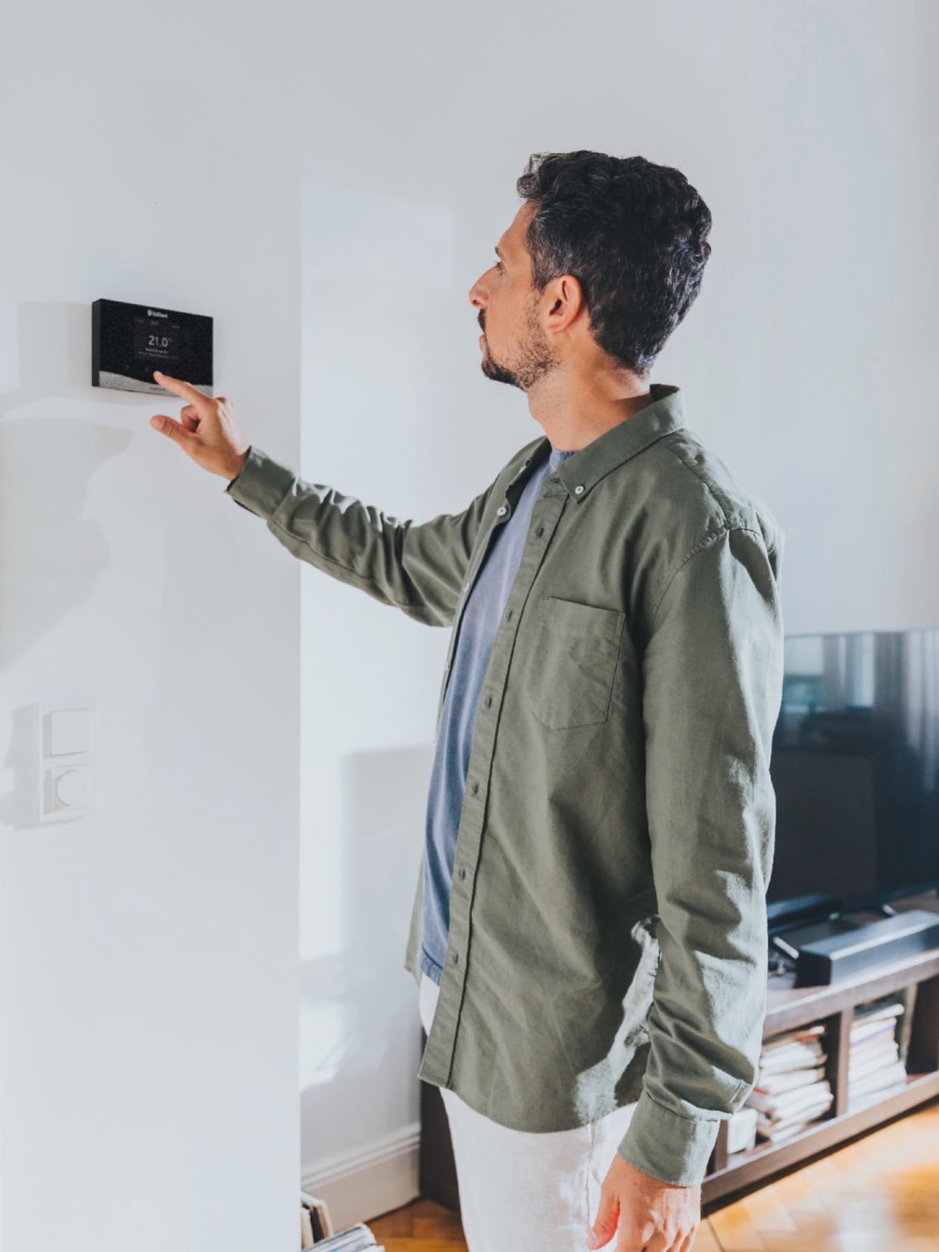 De mens gebruikt de verwarmingsregeling sensoCOMFORT