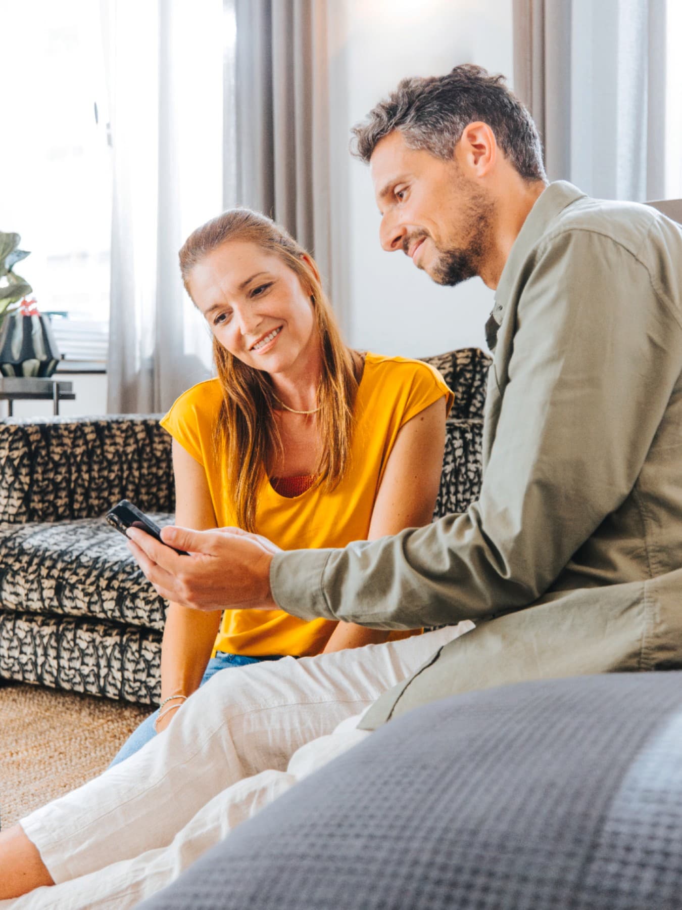 Koppel in de living met smartphone | Vaillant