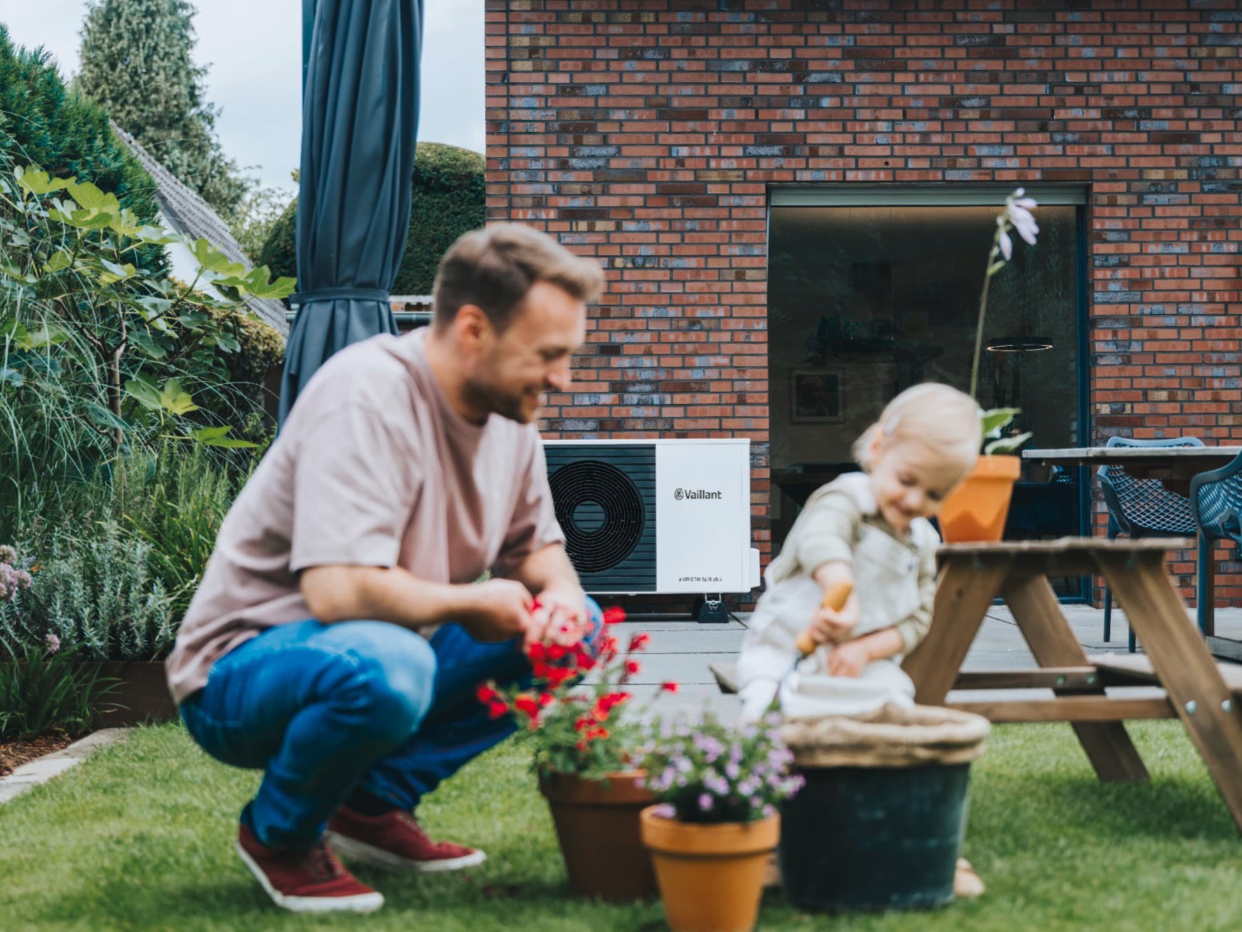Man speelt met kind in de tuin