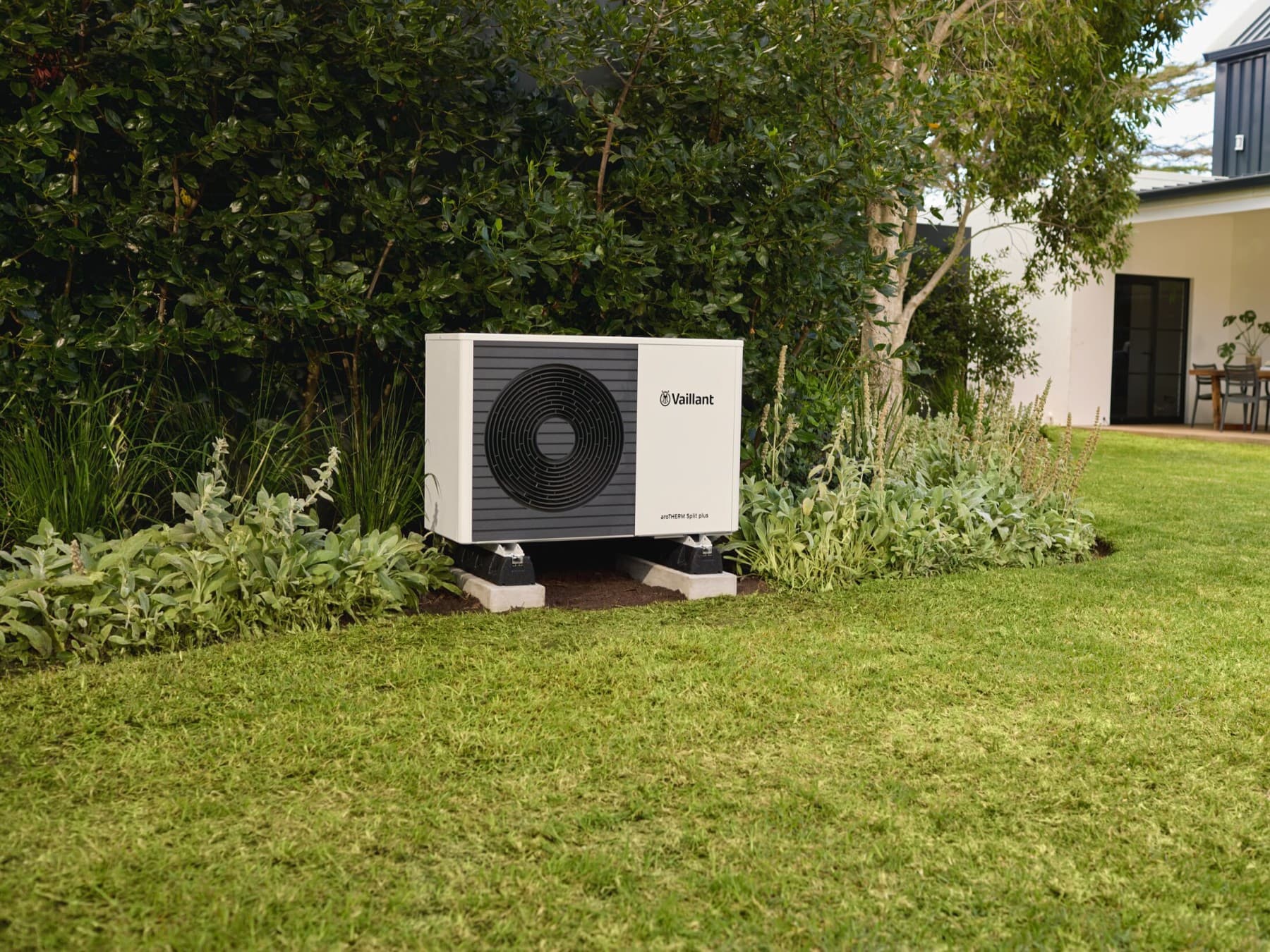 Lucht-warmtepomp op silent blocks in een tuin