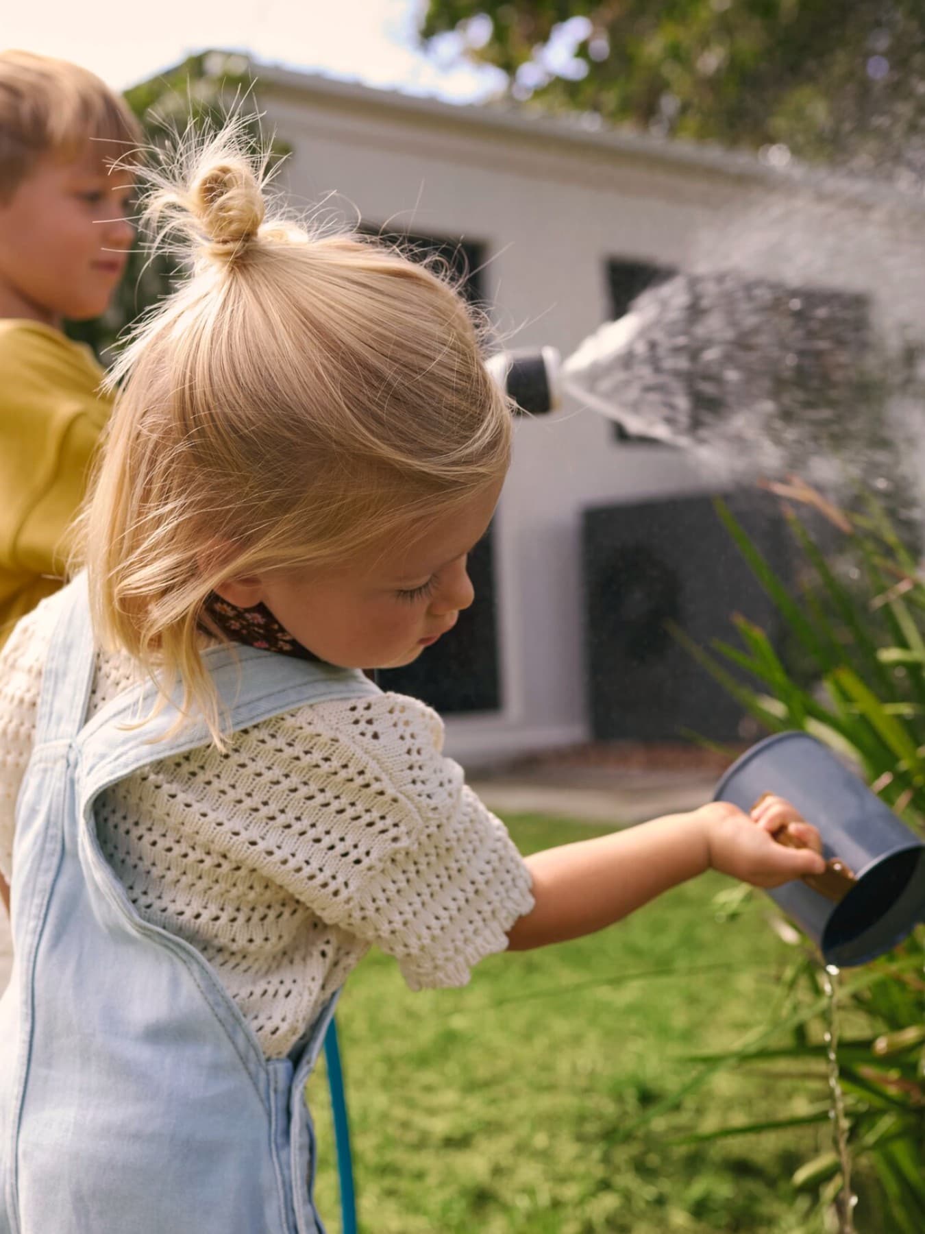 Kinderen geven planten water met een gieter