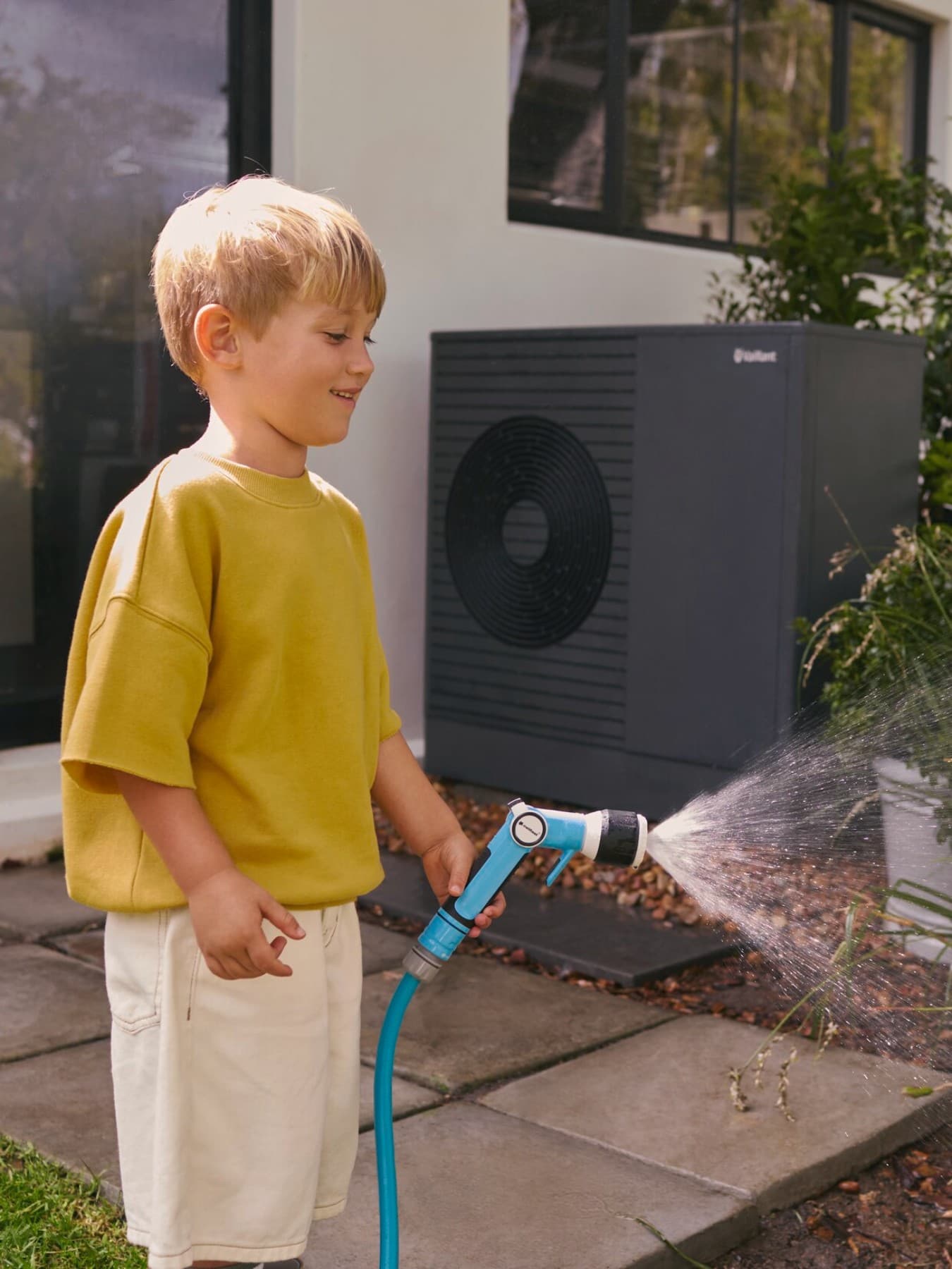 Jongen die op een warmtepomp zit en met munten speelt