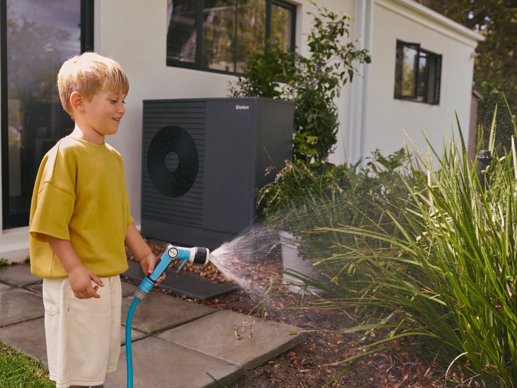 Jongen die op een warmtepomp zit en met munten speelt