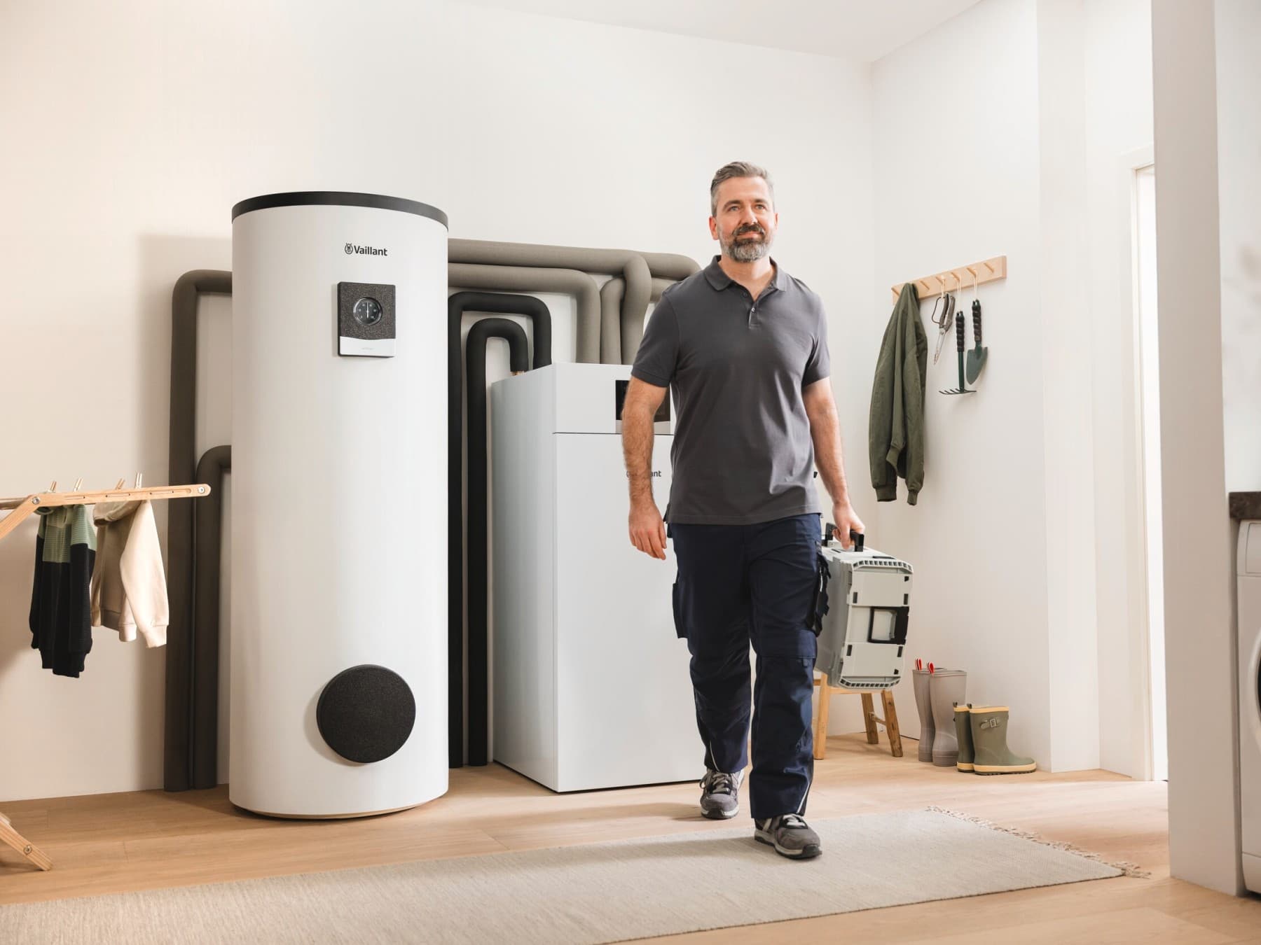 Installateur loopt weg van een installatie met een geothermische warmtepomp en boiler
