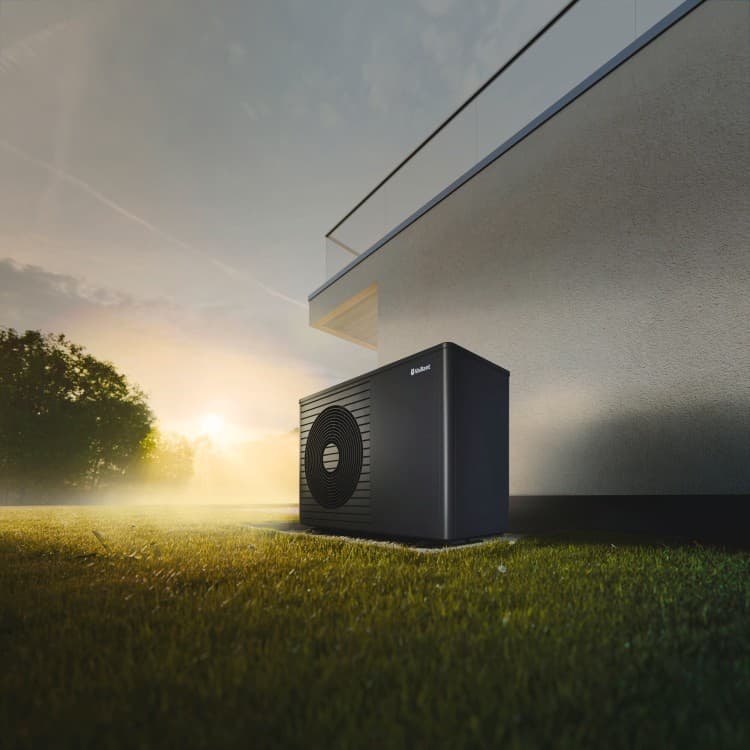 Zwarte warmtepomp naast gevel