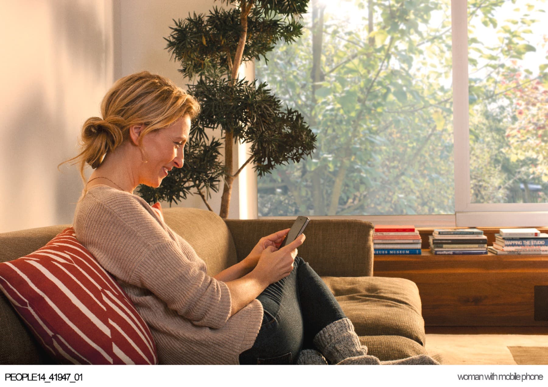 Vrouw zit in de zetel op haar telefoon