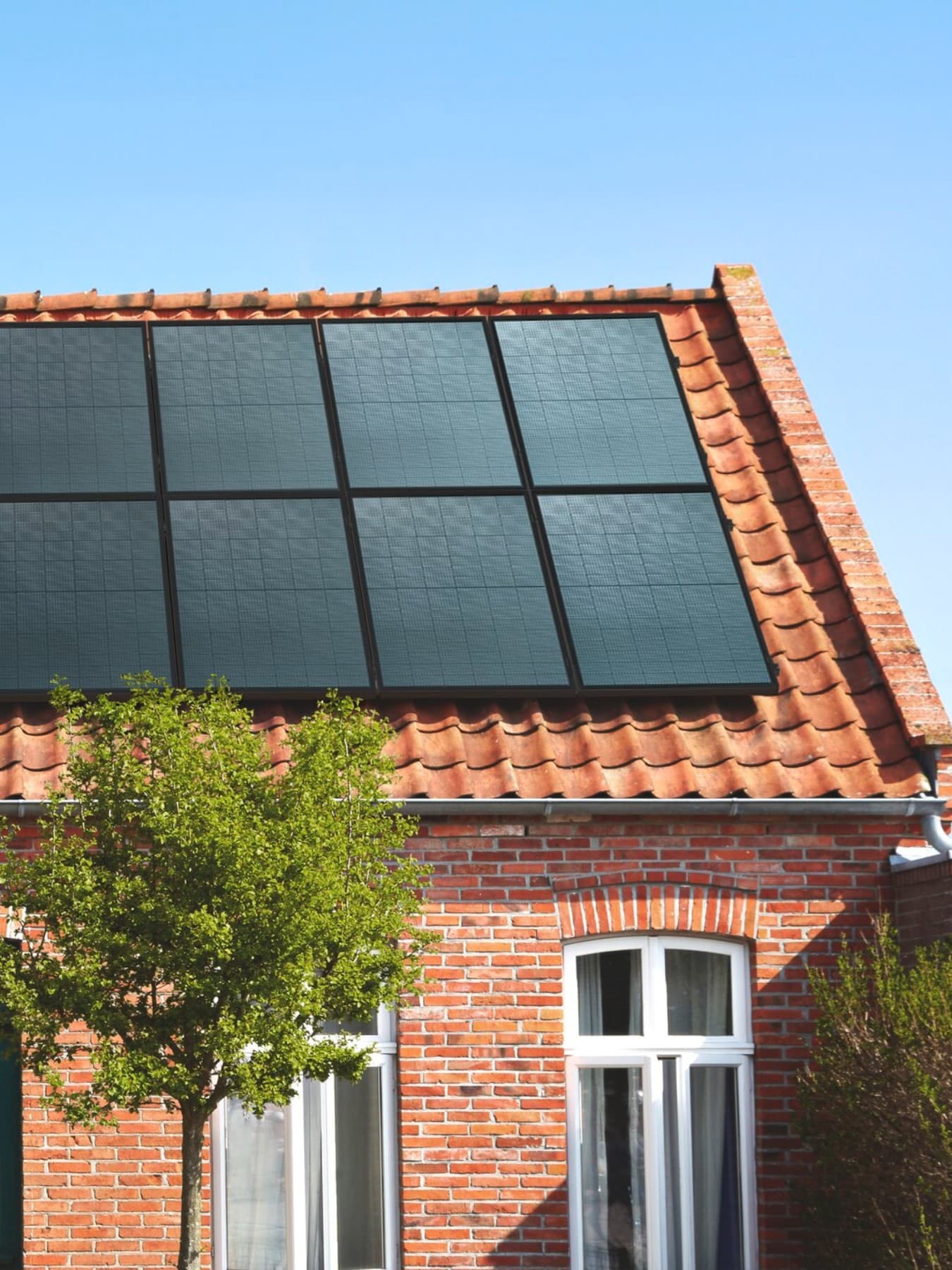 Woning met een oranje pannendak en zonnepanelen op het dak