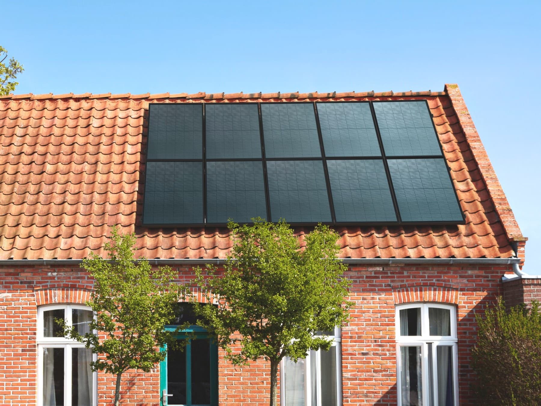 Woning met een oranje pannendak en zonnepanelen op het dak