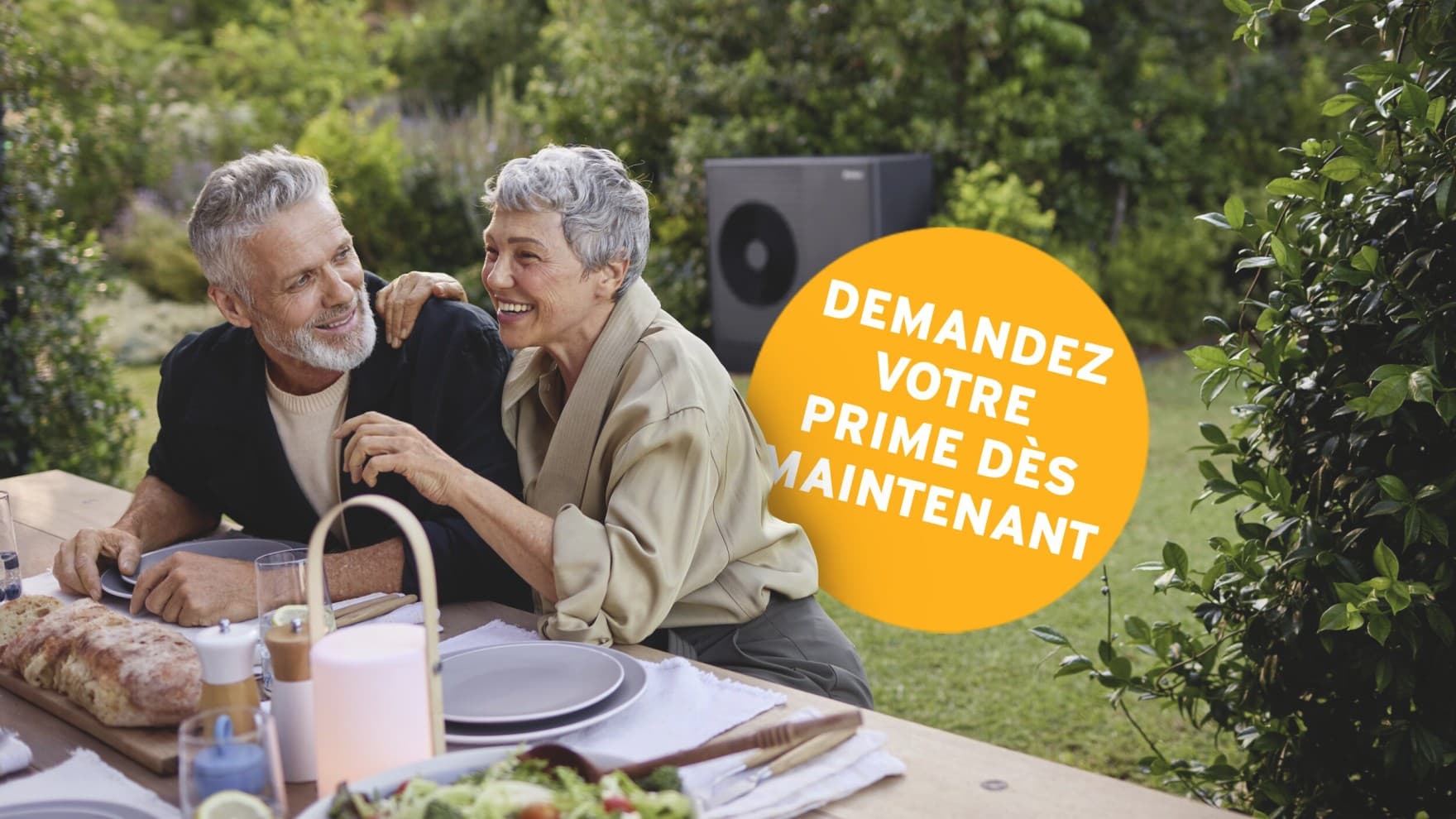 Un couple est assis dans le jardin, avec une boule jaune sur laquelle est écrit « Demandez votre prime dès maintenant »