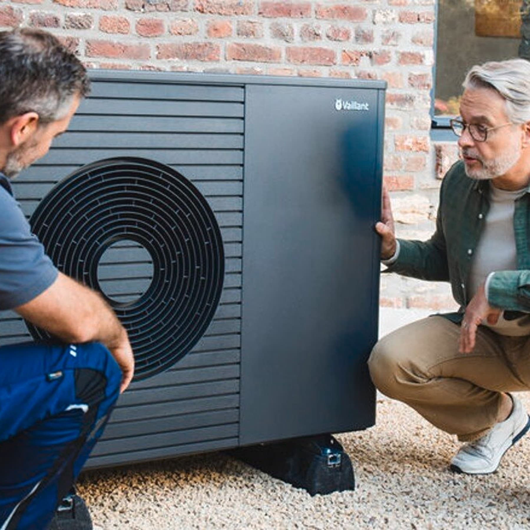 Een installateur en een klant aan een warmtepomp | Vaillant