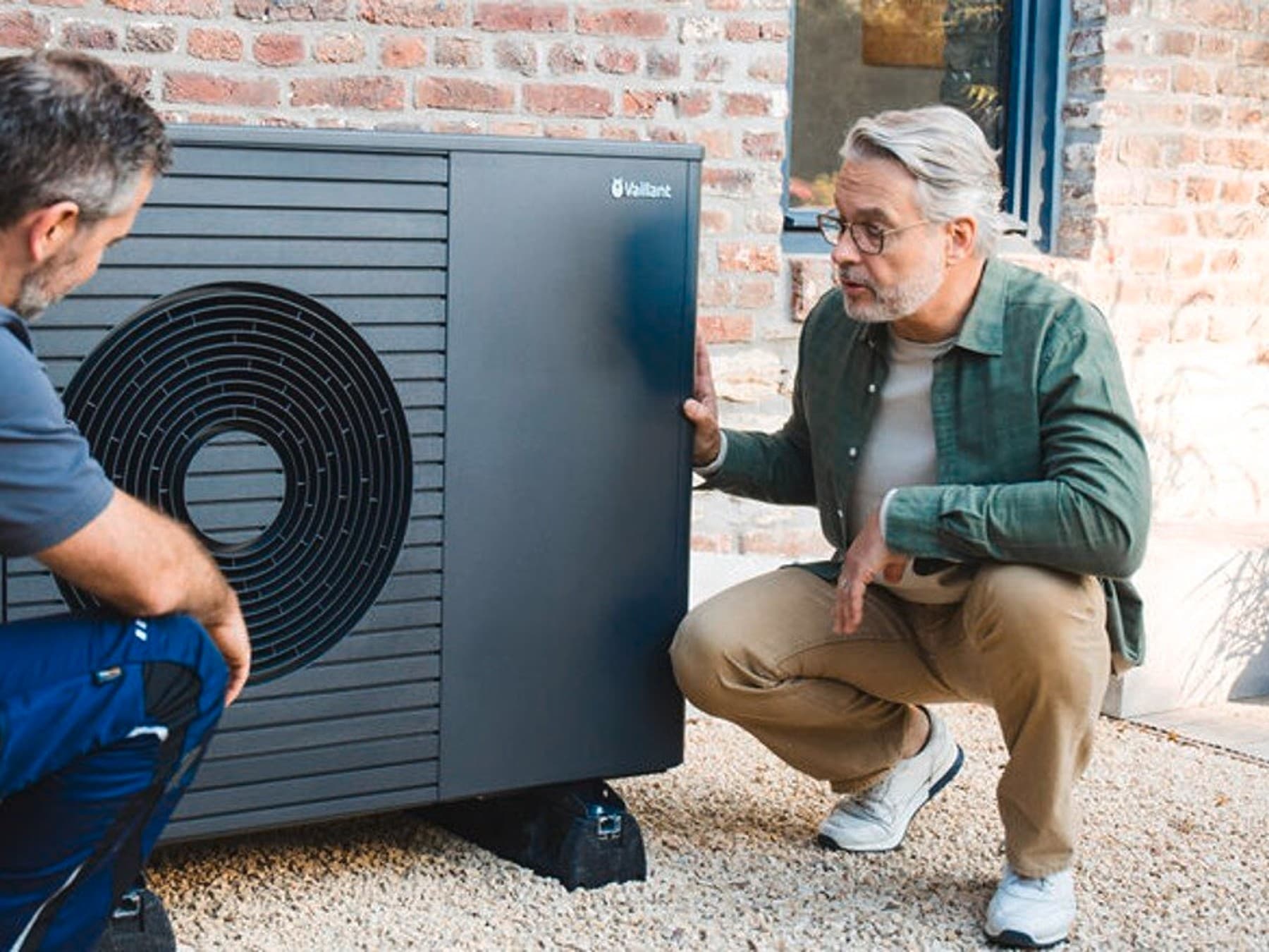 Servicetechnicus die aan een warmtepomp werkt voor een man | Vaillant
