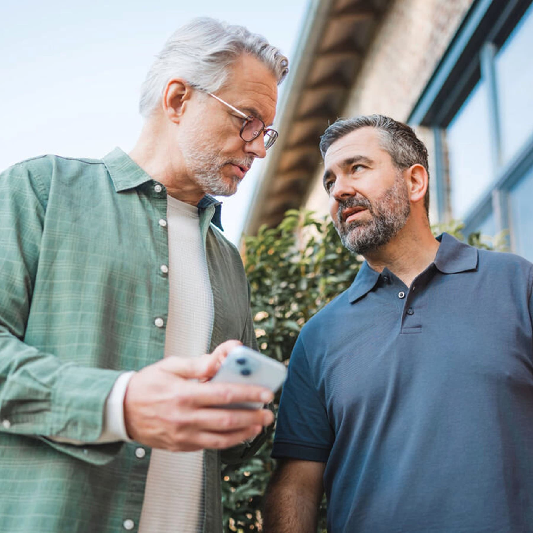 Man die de installateur iets op zijn smartphone laat zien