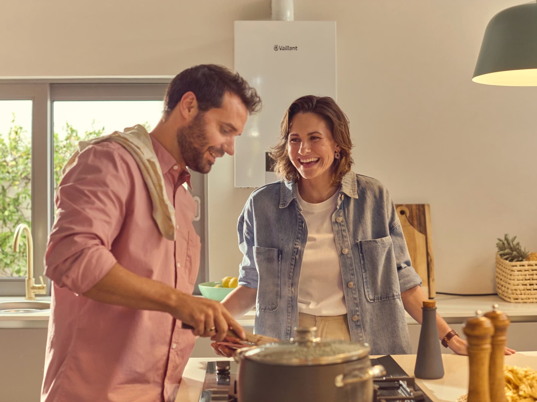 Koppel kookt in de keuken met condensatiegasketel op de achtergrond