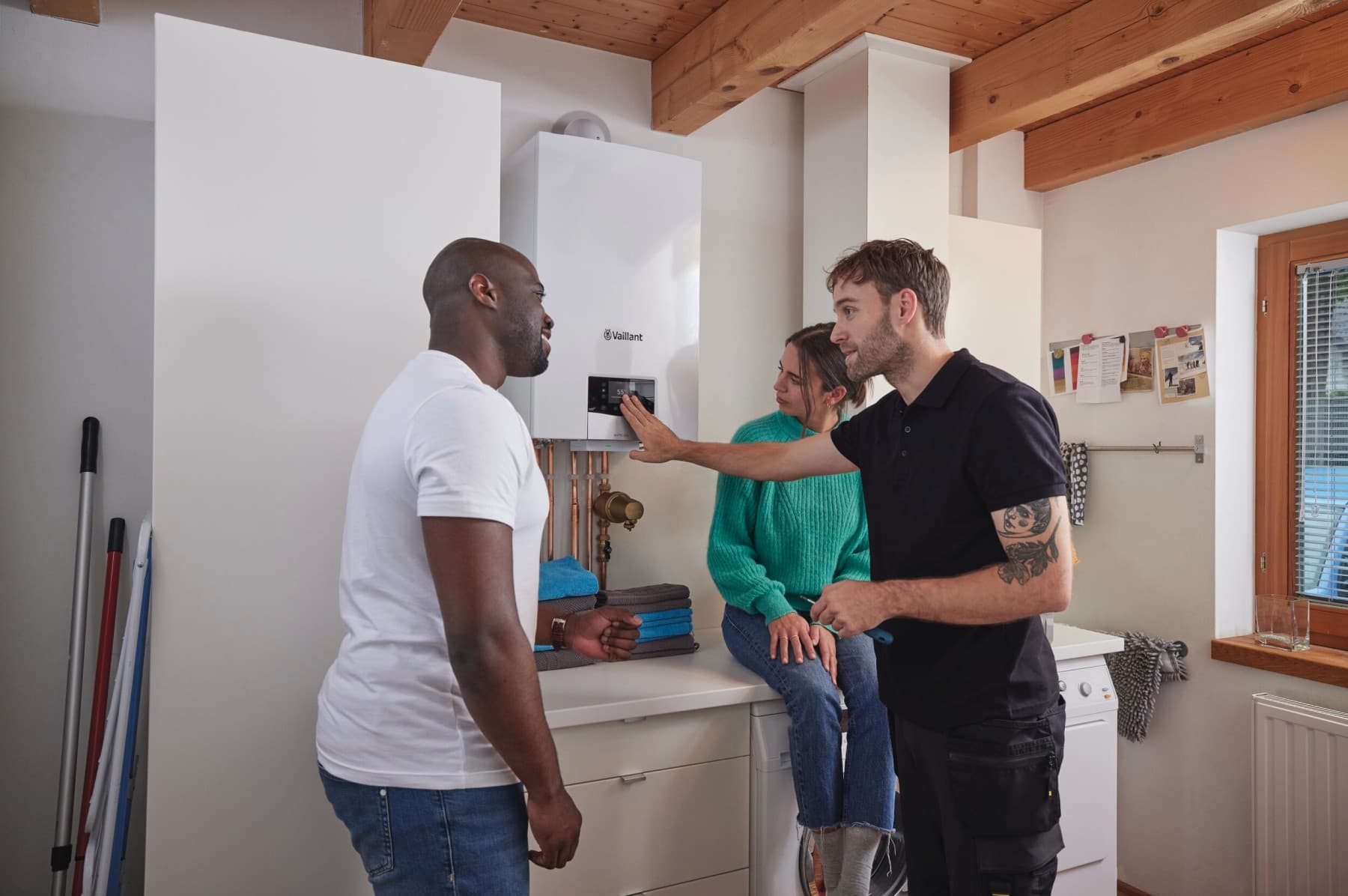 Technieker legt een koppel iets uit naast een wandketel van Vaillant