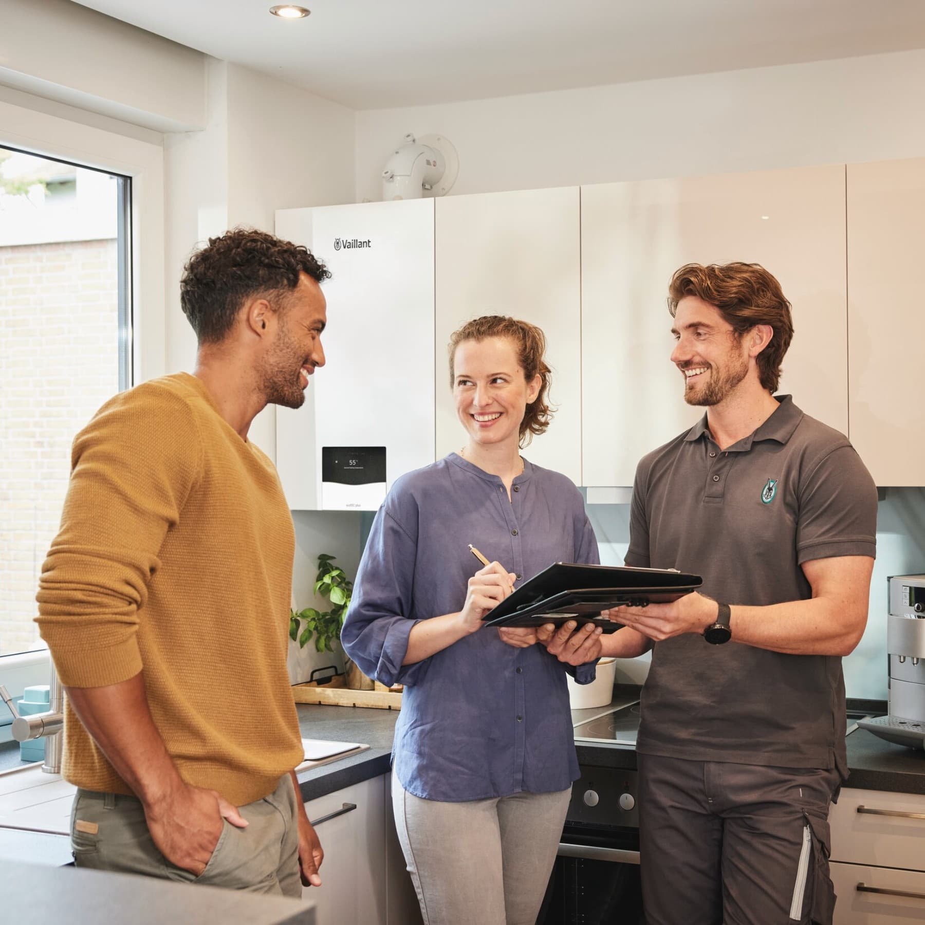 Servicepartner en klant in gesprek in de keuken | Vaillant