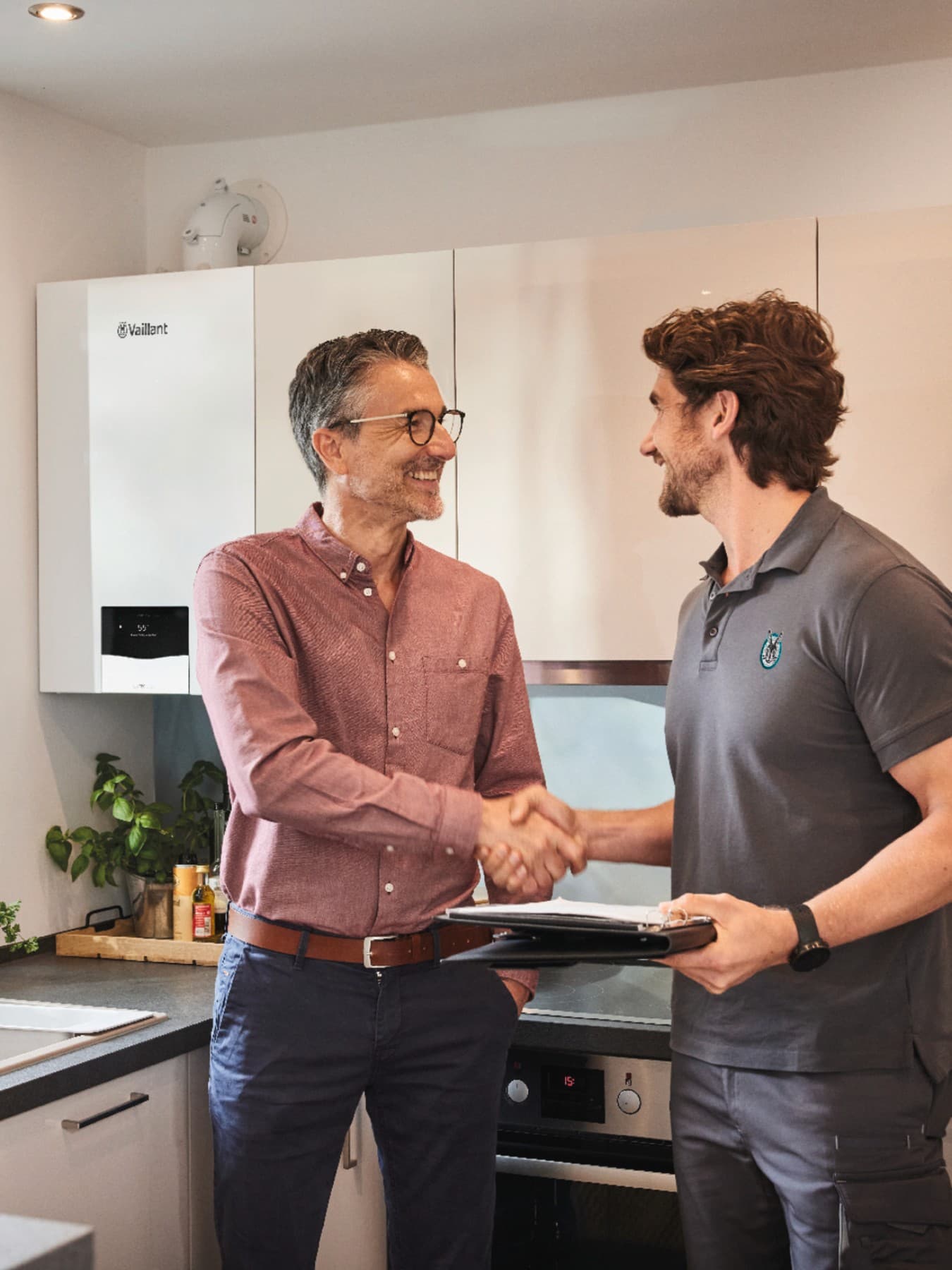 Klant en technieker schudden elkaar de hand in de keuken | Vaillant